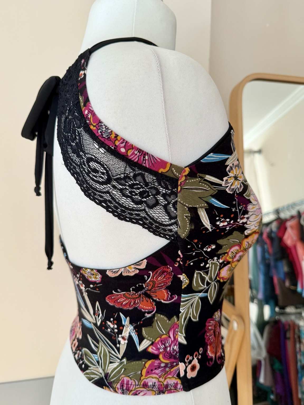 Back view of women’s tango top with an open lace back, adjustable ties, wide shoulder straps, and fitted jersey waist.