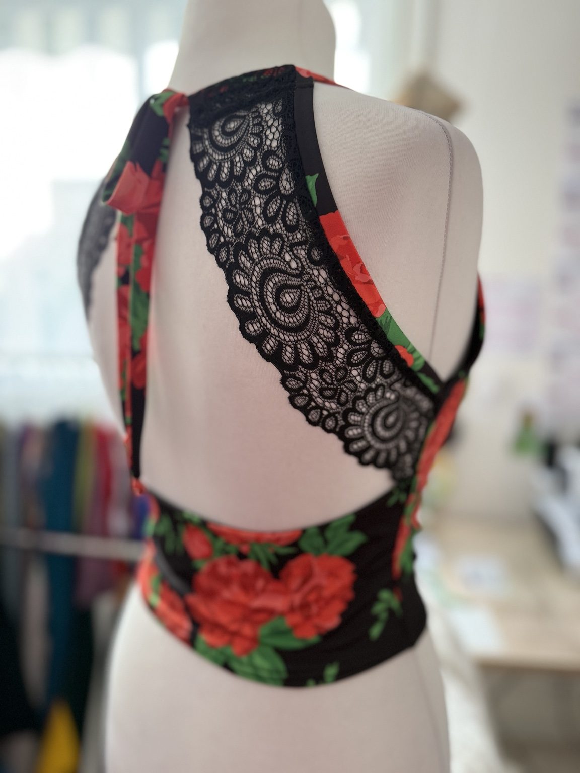 Back view of women’s tango top with an open lace back, adjustable ties, wide shoulder straps, and fitted jersey waist.