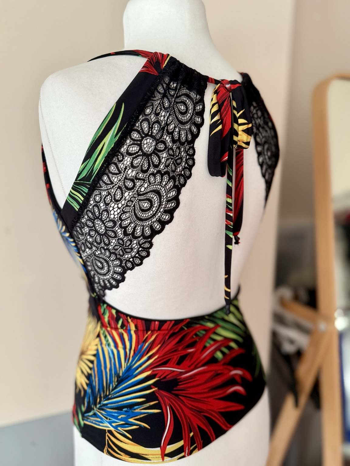 Back view of women’s tango top with an open lace back, adjustable ties, wide shoulder straps, and fitted jersey waist.