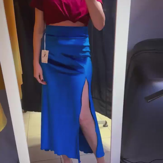 Woman in blue velvet tango skirt in front of the mirror