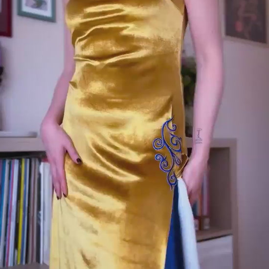 Video of a woman wearing a golden velvet tango dress with blue embroidery