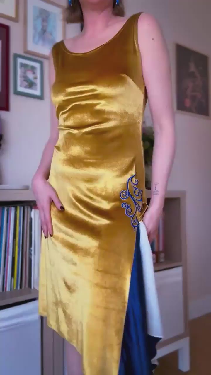 Video of a woman wearing a golden velvet tango dress with blue embroidery