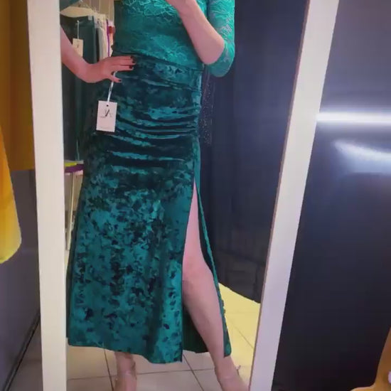 Woman in teal velvet tango skirt looking at the mirror