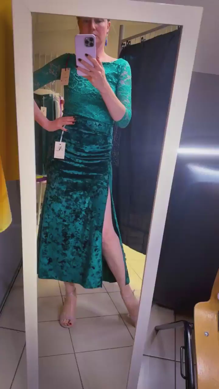 Woman in teal velvet tango skirt looking at the mirror